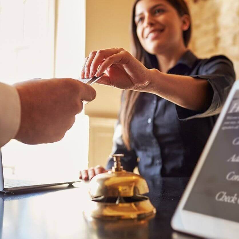 Front desk staff handing a keycard to an arriving swim instructor